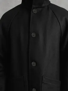 Vue détaillée manteau en laine noir pour homme, veste d'hiver à capuche et raglan.