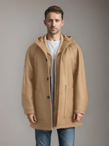 Vue détaillée du manteau en laine camel à capuche, avec grandes poches et manches raglan.