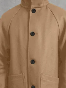 Détail du manteau en laine pour homme avec patte de boutonnage et poches camèle.