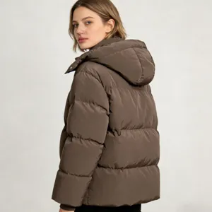 Vue détaillée d'une veste d'hiver matelassée à capuche pour femme marron uni au design douillet.