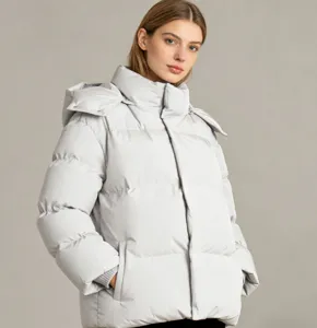 Détail en gros plan de la veste matelassée d'hiver douillette à capuche gris clair.