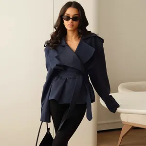 Close-up detail of the elegant navy blue trench coat featuring a chic lapel and waist belt.