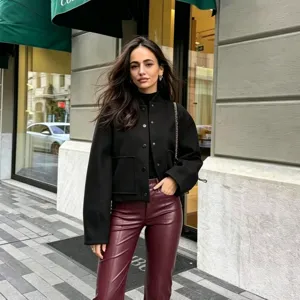 Detailed scene shot showing a chic black stand collar bomber jacket featuring large pockets.