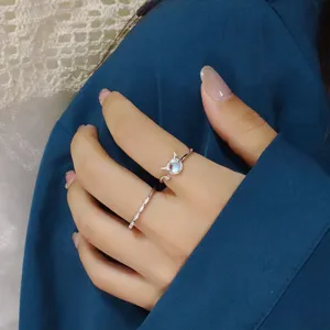 Detailed shot of a dainty silver little devil ring with moonstone on a model's hand