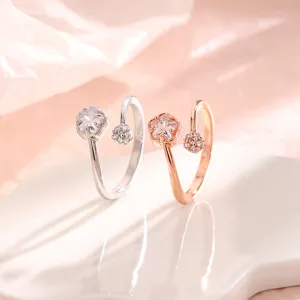 Vue détaillée de bagues fleur de cerisier en argent et or rose avec cristaux étincelants.