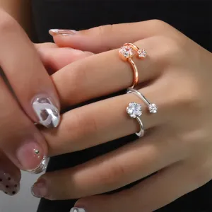 Détail de bagues fleurs de cerisier en or rose et argent avec des cristaux étincelants