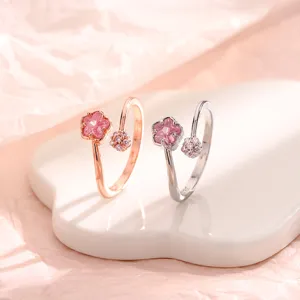 Vue détaillée de deux élégantes bagues fleurs de cerisier en or rose et argent avec cristaux