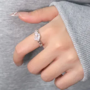 Detail view of pink zircon cat ring with heart-shaped paw design worn on finger