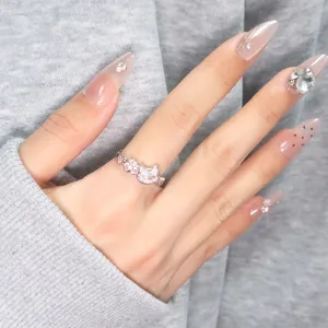 Close-up detail of a pink cubic zirconia cat ring with heart and paw print designs.