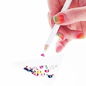 Macro view of white rhinestone picker pencil lifting colorful crystal gem