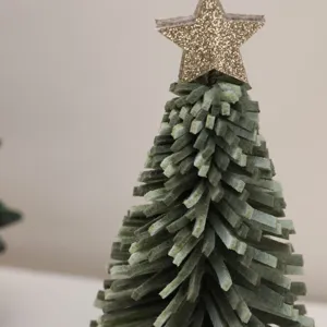 Macro detail of a mini felt Christmas tree featuring a sparkling golden glitter star topper