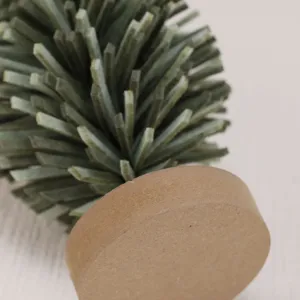 Detailed close-up of the felt layers and round wooden base of a mini Christmas tree.