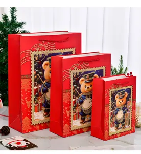 Drei rote Weihnachtsgeschenktüten mit niedlichem Bärenmotiv und goldenem Glitzer-Effekt.