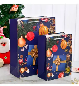 Detail of blue Christmas gift bags set with festive ornaments and white rope handles