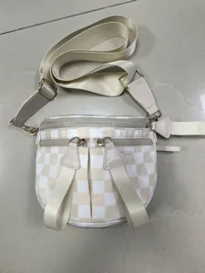 Vista detallada del mini bolso bandolera de tela Oxford a cuadros beige para mujer