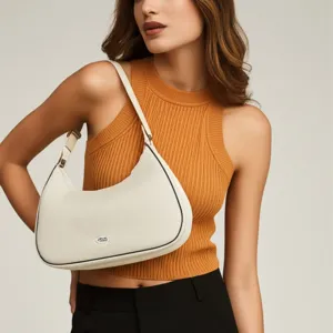 Detalle de un bolso de luna acolchado blanco crema usado como bolso de hombro chic.