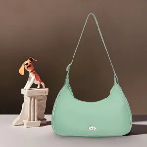 Detalle de un bolso de nube acolchado en color verde menta con forma de media luna.
