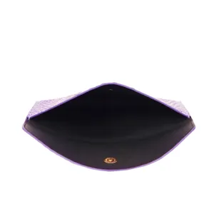 Detalle del bolso de mano violeta con textura de cocodrilo y botón dorado