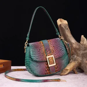 Vista detallada de un bolso baguette de cuero con relieve de cocodrilo y efecto degradado