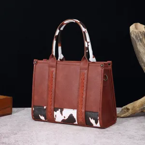 Bolso tote marrón estilo western vintage con detalles de estampado de vaca y trenzado.
