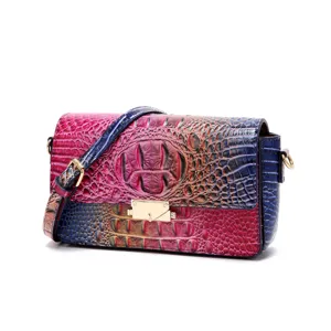 Detalle de bolso bandolera retro con un vibrante estampado de cocodrilo en degradado