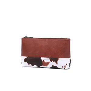 Detalle de bolsa retro estilo occidental con cuero sintético marrón y estampado de vaca
