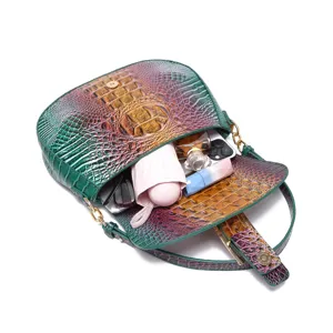 Detalle del bolso baguette con relieve de cocodrilo que muestra el interior espacioso