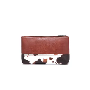Primer plano de un bolso retro de cuero marrón con estampado de vaca y cremallera