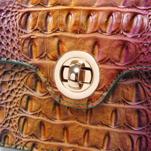 Close-up of golden twist lock on retro multi-color crocodile pattern leather handbag
