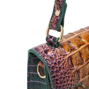 Macro detail showing luxury crocodile embossed leather texture and gold hardware of handbag.