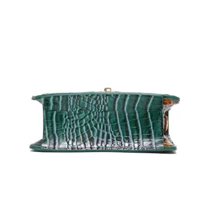 Detailed view of green crocodile embossed texture on bottom of a vintage handbag