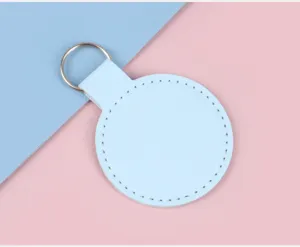 Gros plan d'un porte-clés circulaire en simili cuir bleu clair avec de fines coutures.