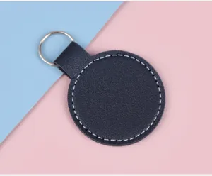 Vue détaillée du porte-clés en cuir rond bleu marine avec surpiqûres blanches