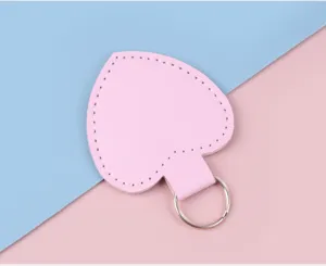 Detail eines herzförmigen rosa Leder-Schlüsselanhängers mit silbernem Metallring.