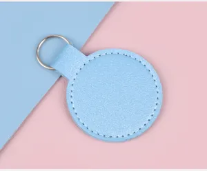 Gros plan d'un porte-clés circulaire en cuir bleu clair avec d'élégantes coutures
