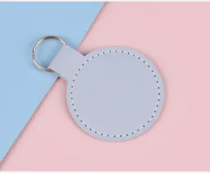 Vue macro d'un porte-clés en cuir bleu clair circulaire sur un fond rose et bleu