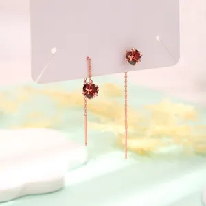 Makro-Detail von roten Zirkon-Würfel-Ohrketten in einer edlen Roségold-Ausführung