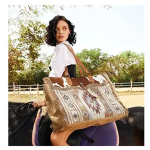 Lifestyle view of a vintage Bohemian canvas tote bag carried by a model on horseback.