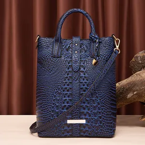 Bolso tote azul con textura de cocodrillo en relieve, correa y herrajes dorados