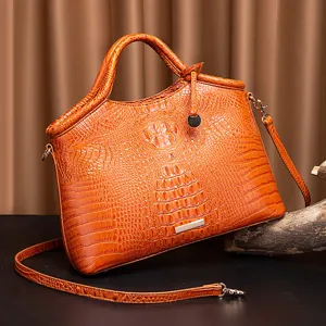 Vista de cerca de la textura de cocodrilo grabada de alta calidad en un bolso retro naranja