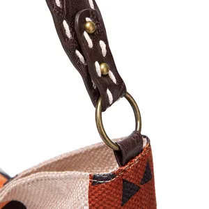 Detailed view of a vintage bag strap with white stitching and bronze hardware ring.