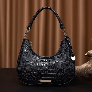Primo piano di borsa hobo nera retrò con texture coccodrillo goffrata e finiture dorate