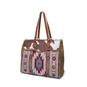 Large vintage Bohemian canvas tote bag featuring cow print and ethnic fringe details