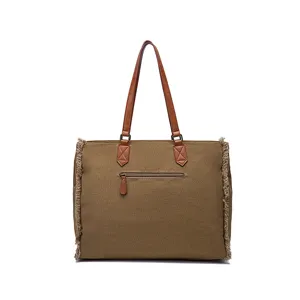 Rear view of brown canvas tote bag featuring fringe details and zipper pocket
