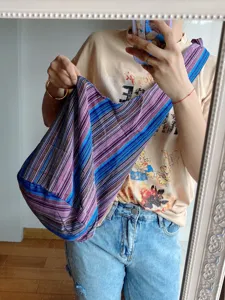 Bolso de hombro retro de lona a rayas aztecas mostrado en un selfie frente al espejo