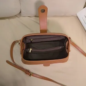 Internal view of brown vintage doctor bag with double zipper pockets and fabric lining.