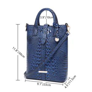 Bolso bandolera azul con relieve de cocodrilo, medidas en centímetros y pulgadas.