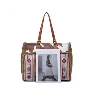 Large bohemian canvas tote bag featuring cow print and ethnic woven patterns with fringes