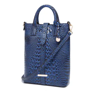 Detalle de un bolso retro azul para mujer con un elegante relieve de cocodrilo chic