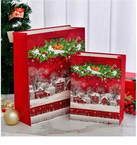 Close-up of red Christmas gift bags with glitter snowy village and festive decor